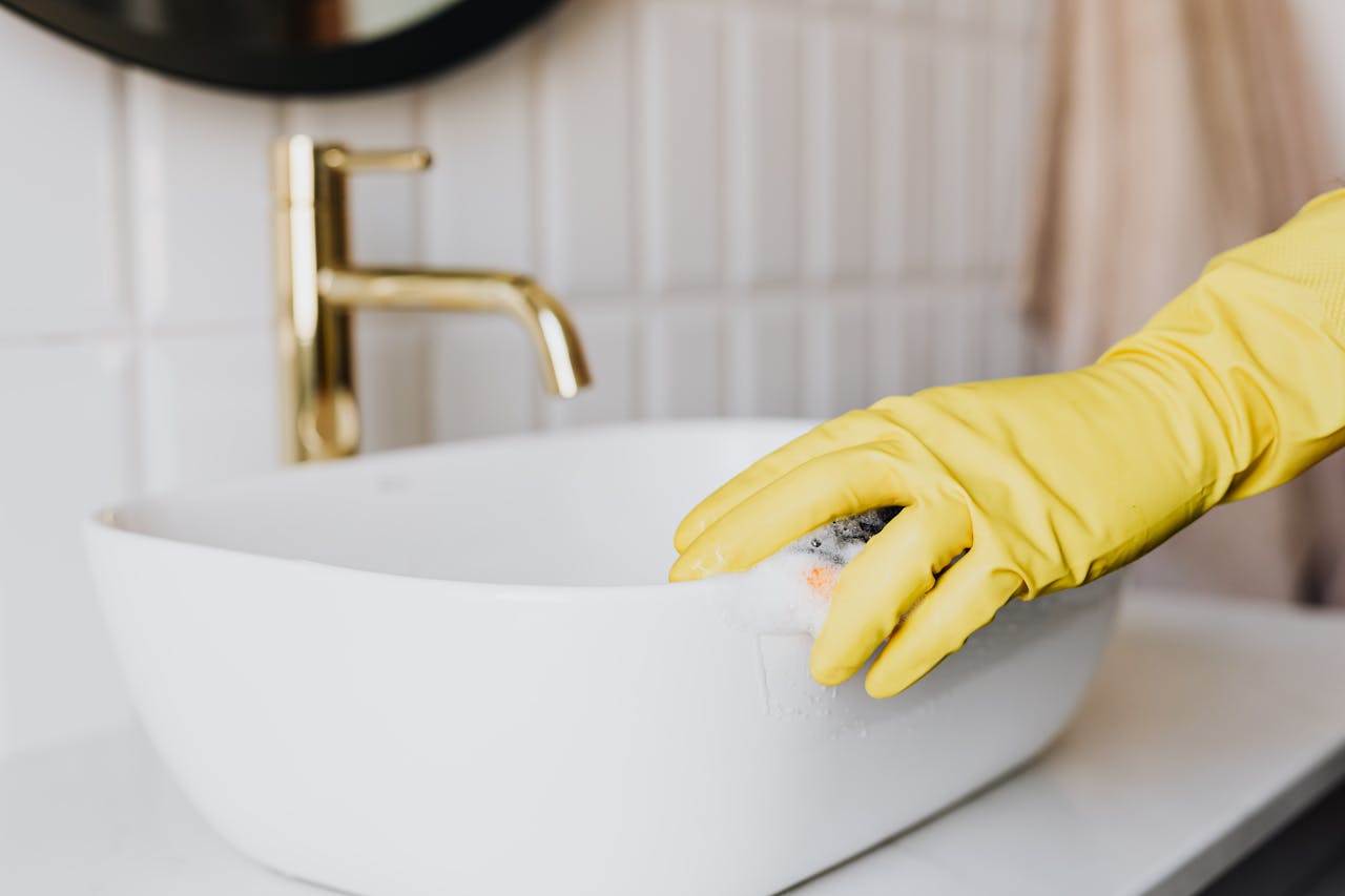 Crafting Captivating Headlines: Your awesome post title goes here Crop faceless person in yellow latex protective glove cleaning surface of white stylish sink in contemporary bathroom interior